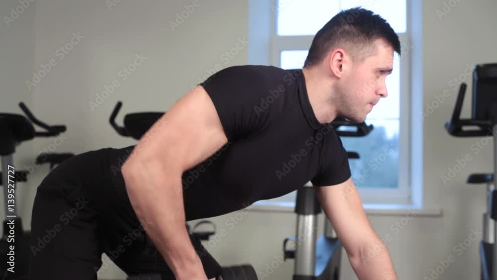 bodybuilder working out with bumbbells weights at the gym