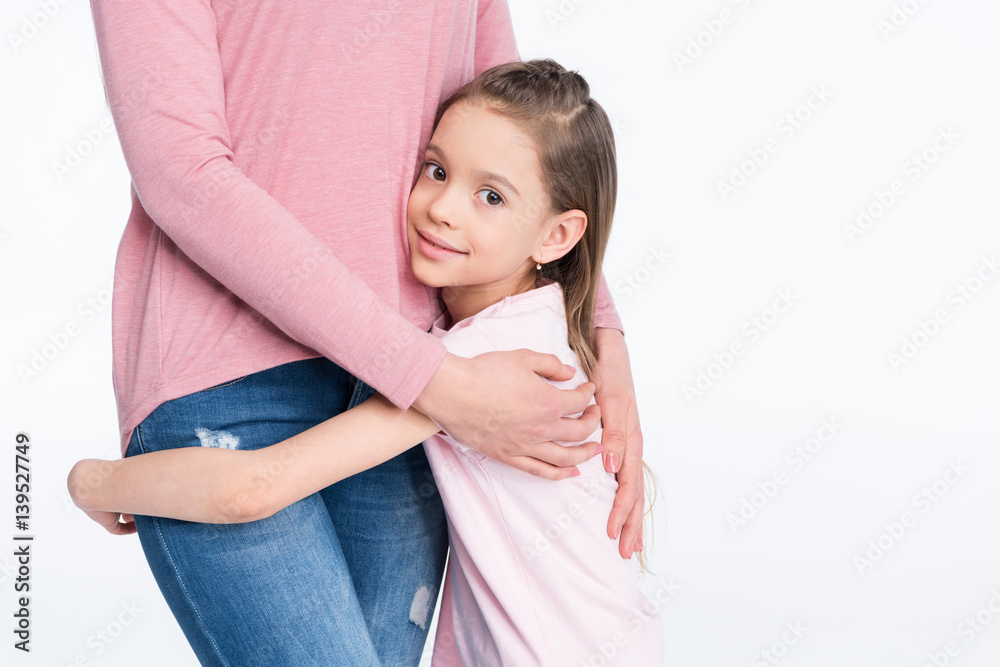 Cropped shot of happy little girl hugging mother on white Cropped shot of happy little girl hugging mother on white
