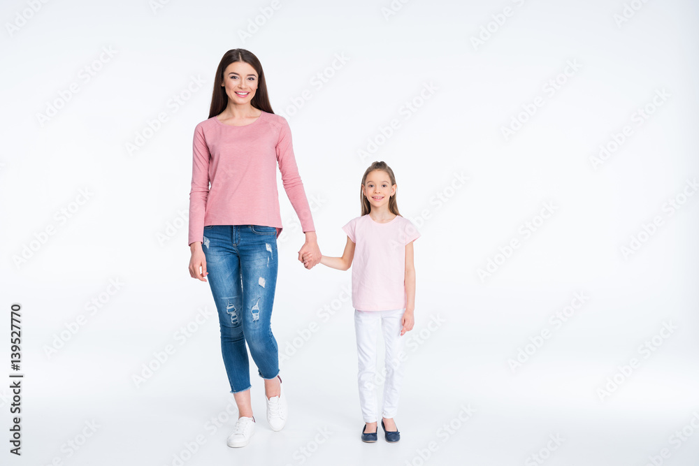 Happy mother and daughter holding hands on white Happy mother and daughter holding hands on white
