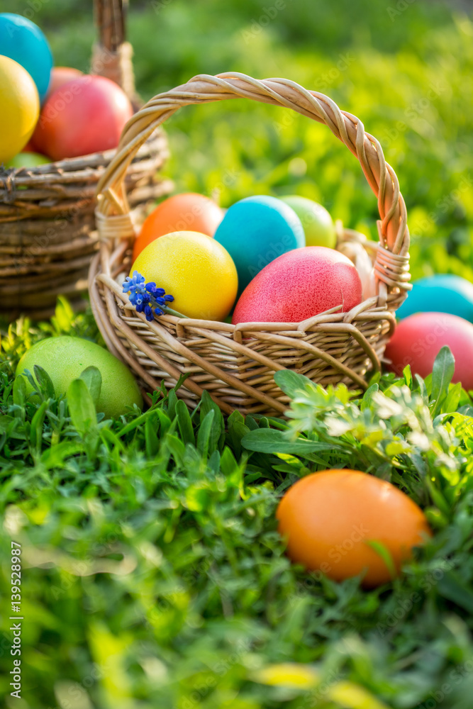 Happy Easter. Happy Easter. Colorful Easter eggs in wicker baskets, in open air. Happy Easter. Happy Easter. Colorful Easter eggs in wicker baskets, in open air.