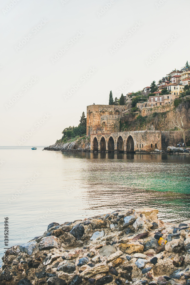 Alanya ancient medieval fortress towers, wall and shipyard and still Mediterranean sea, Turkey