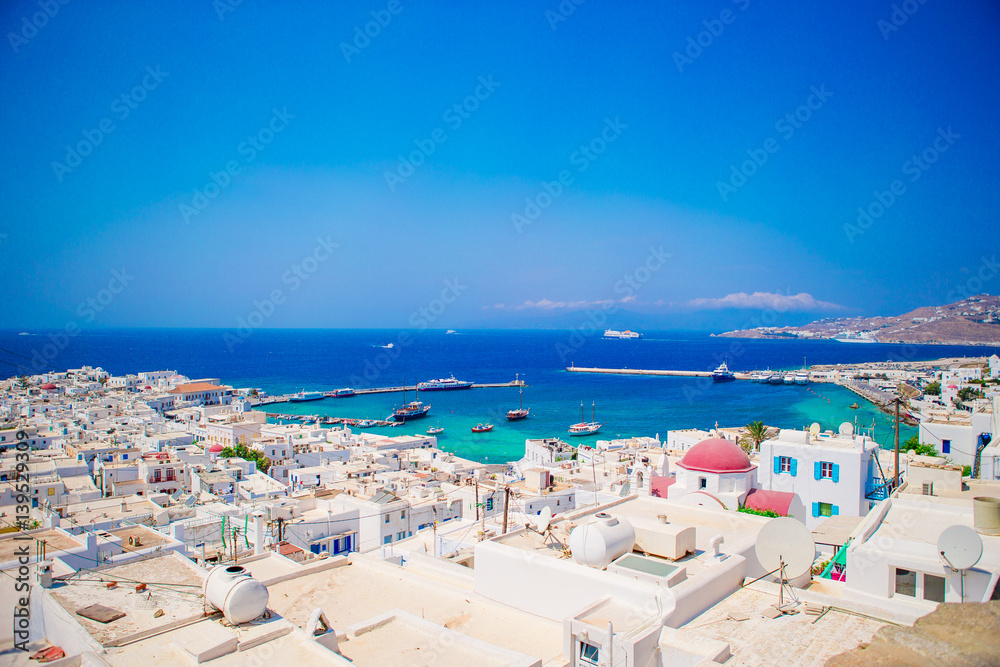 Top view of the old city and the sea on the island of Mykonos, Greece. A lot of white houses against the blue sky