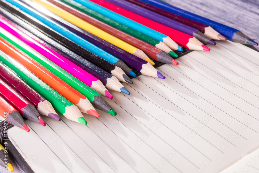 Color pencils on note background. Top view. Copy space. Color pencils on note background. Top view. Copy space.