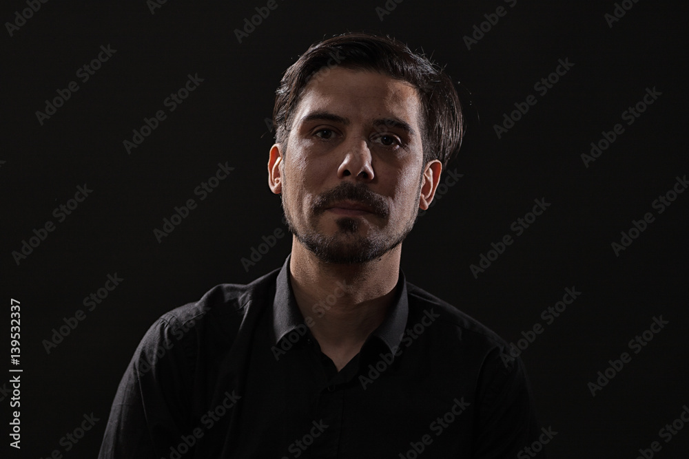 Portrait of adult man on black background.