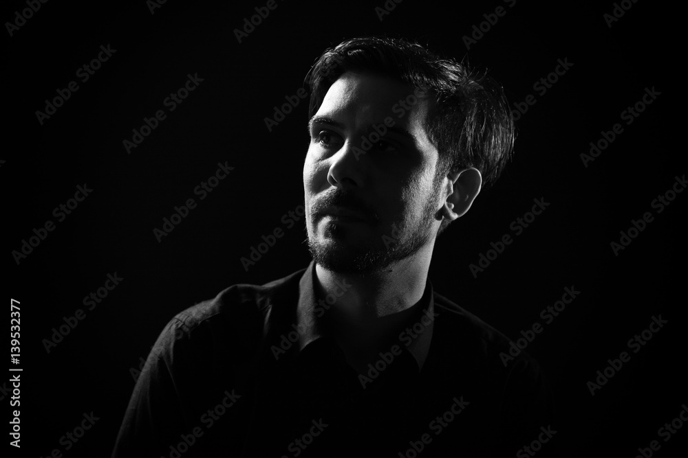 Portrait of adult man on black background. Black and white image.