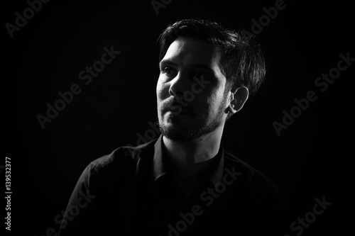Portrait of adult man on black background. Black and white image.