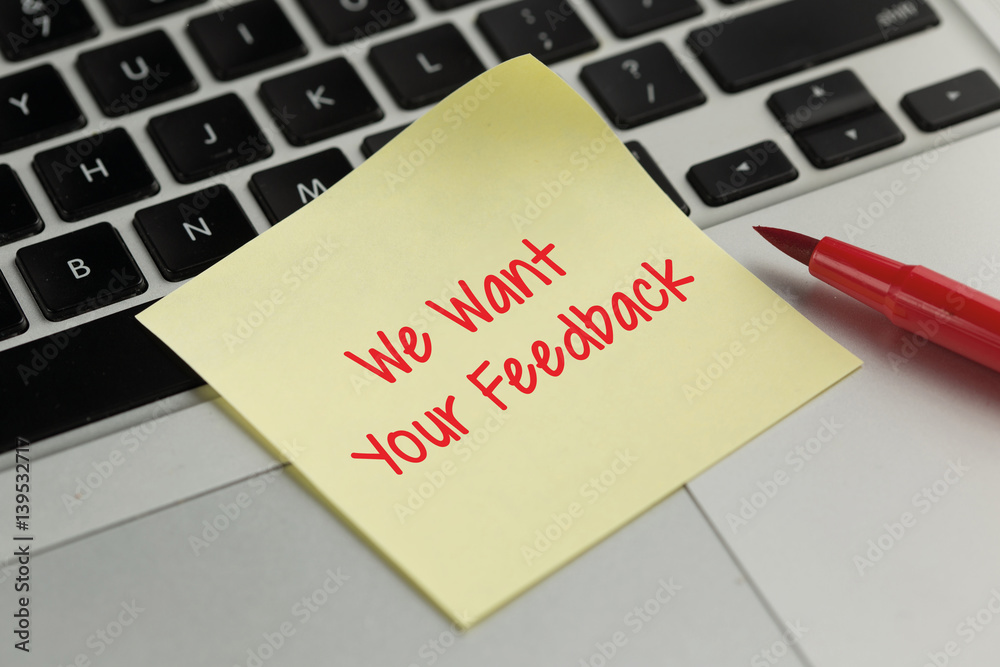 We Want Your Feedback sticky note pasted on the keyboard We Want Your Feedback sticky note pasted on the keyboard