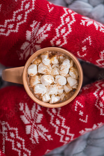 Female feet and cup with hot chocolate photo
