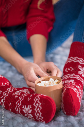 Female feet and cup with hot chocolate photo
