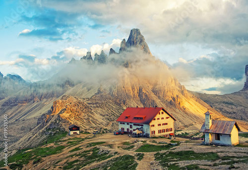 Scenic view of mountain hut and chapel at sunset in Dolomites, Italy photo