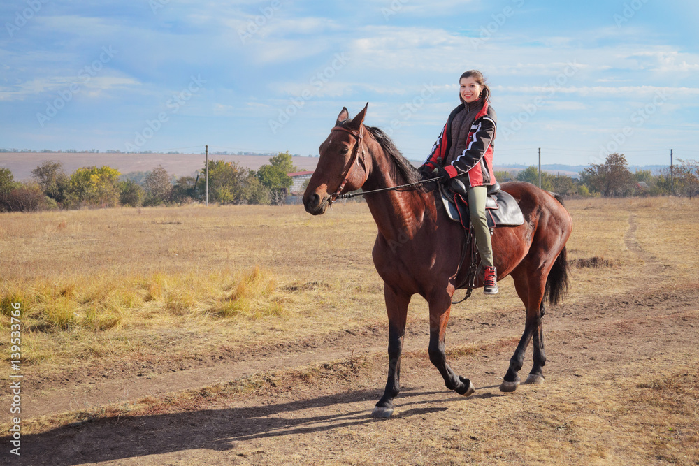 Young female rider on bay horse