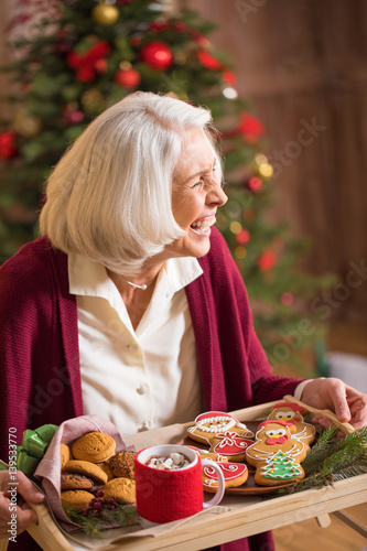 Woman holding tray with christmas cookies photo