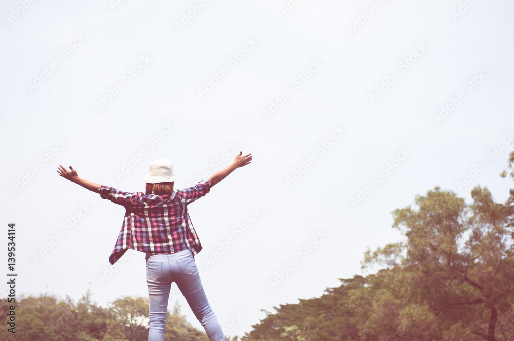 woman jumping enjoying relax on green grass and flower field in park woman jumping enjoying relax on green grass and flower field in park
