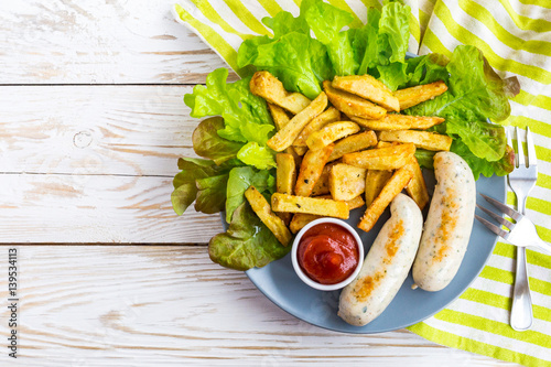 French fries, ketchup, grilled sausages and green salad.