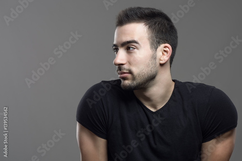 Handsome hunky man profile looking at copy space over dark gray studio background. photo