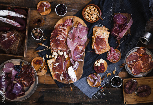 Tapas selection. A cutting board with charcuterie. Spanish cured meat, jamon, lomo, chorizo, salchichon. Charcuterie concept. Top view.