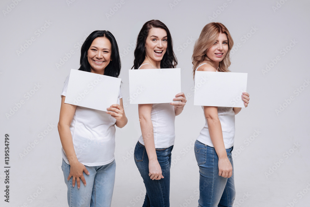 Charming beautiful ladies making similar poses Charming beautiful ladies making similar poses