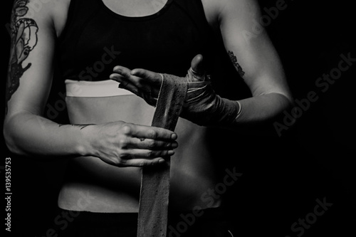 Close-up of a woman wrapping hands with boxing wraps