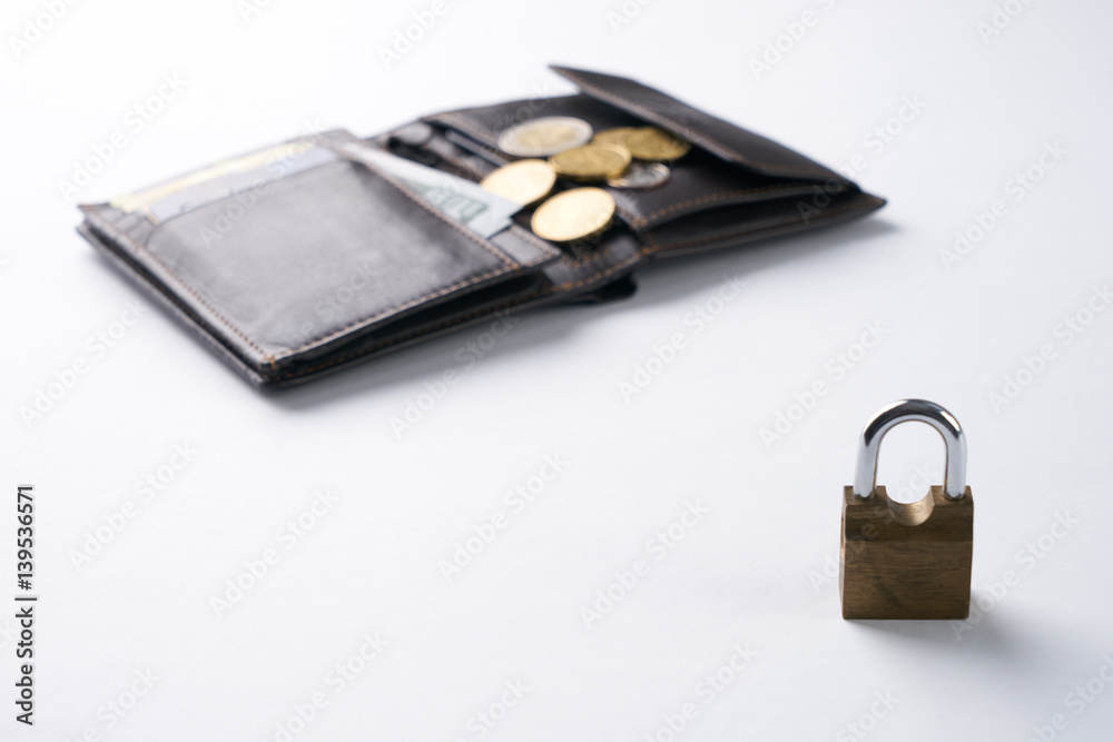Open brown leather wallet with dollar cash, coins, debit credit cards inside and locked padlock.Business safety and finance protection concept