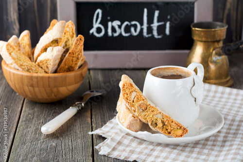 Slika na platnu Homemade biscotti with nuts and a cup of coffee on the old wooden table background