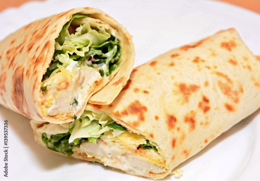 Tortilla wraps with chicken nuggets, fresh vegetable and salad. Stock Photo  | Adobe Stock