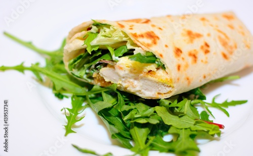 Tortilla wrap with chicken nuggets, fresh vegetable and salad.