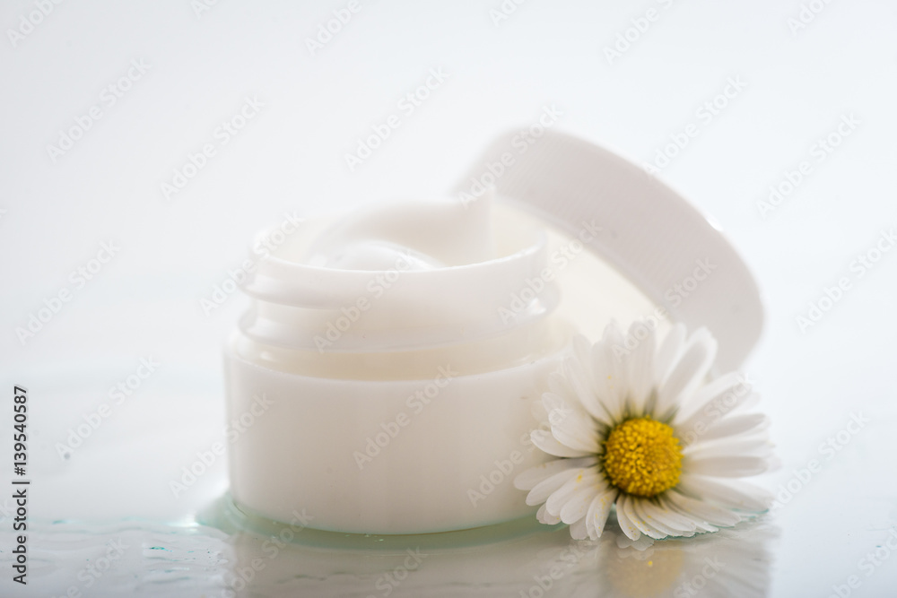 Face cream with spring flowers on white background Face cream with spring flowers on white background