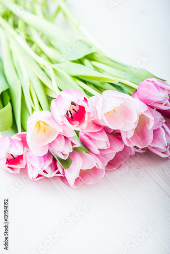 Bouquet of pink tulips on a light background. Holiday card.