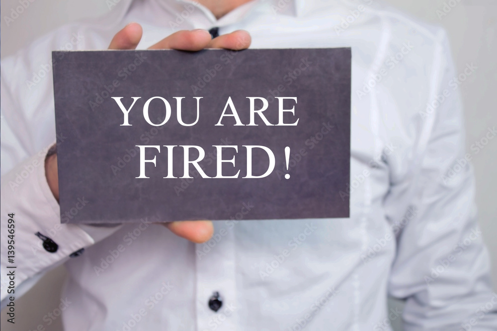 You are fired! - Businessman holding chalkboard with text.