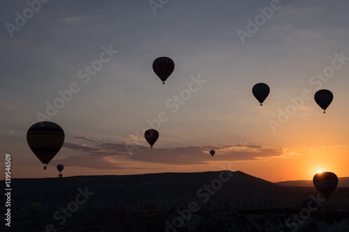 Hot air balloons silhouette over spectacular Cappadocia.