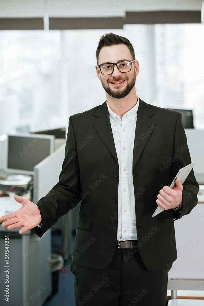 Vertical image of Bearded business man holding tablet computer Vertical image of Bearded business man holding tablet computer