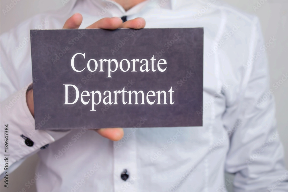 Corporate Department - Businessman holding chalkboard with text. Corporate Department - Businessman holding chalkboard with text.