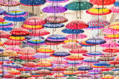 Colorful umbrellas on the ceiling of the largest mall in the world Dubai Mall UAE.