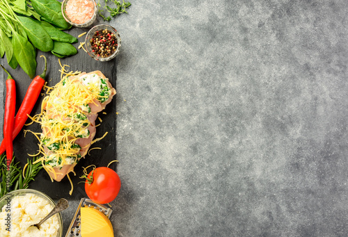 Prepared for cooking chicken fillet with spinach and cheese on a dark background. Top view   copy space.