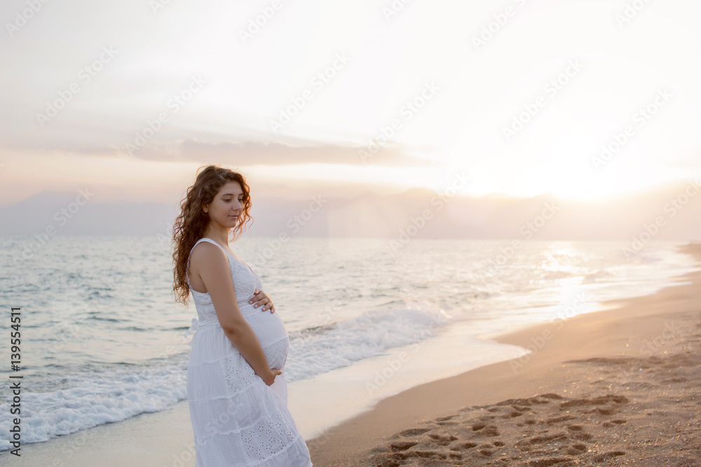 Pregnant couple in love on the beach