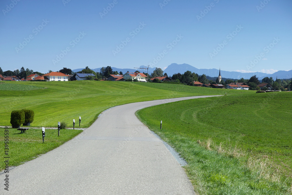 View of the buildings, green fields and blue sky in Chiemsee