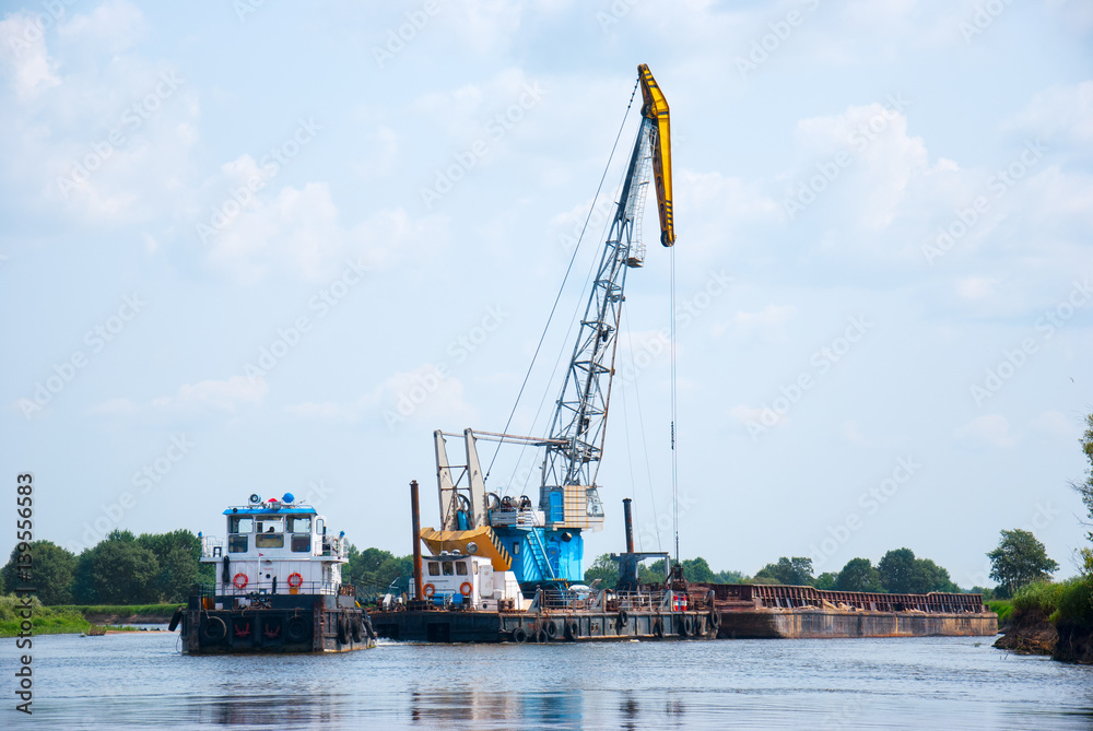 Fototapeta premium The cargo barge floats on the river