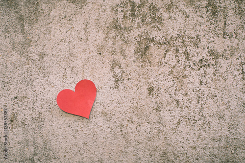 red paper heart shape on concrete background