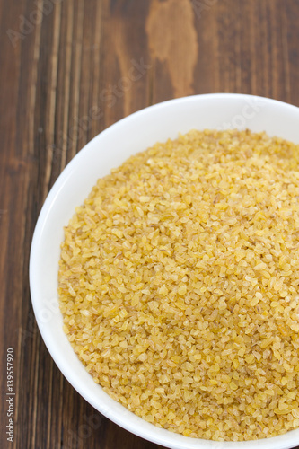 bulgur on white dish on brown background