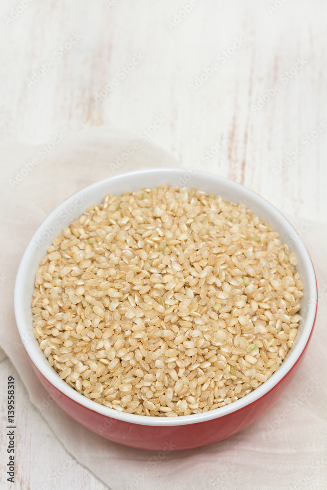 raw rice in red bowl on wooden background raw rice in red bowl on wooden background