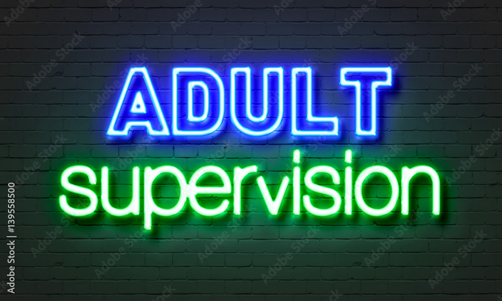Adult supervision neon sign on brick wall background.