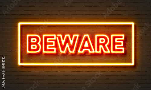 Beware neon sign on brick wall background. photo