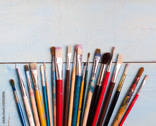 Brushes on the blue wood background. The workplace of the artist. Banner for school