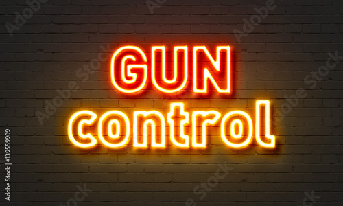 Gun control neon sign on brick wall background.