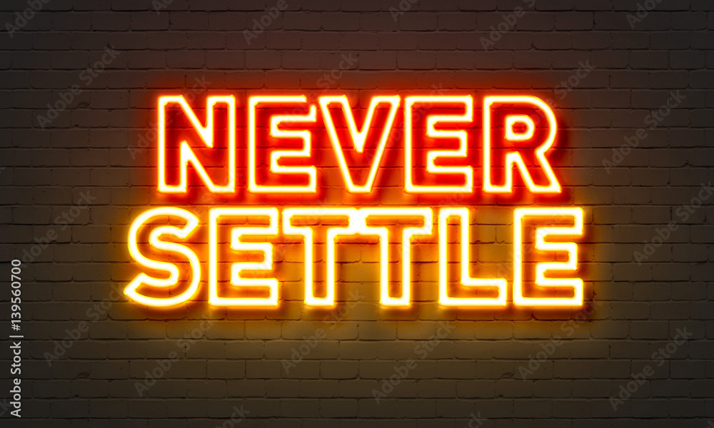 Never settle neon sign on brick wall background. Never settle neon sign on brick wall background.