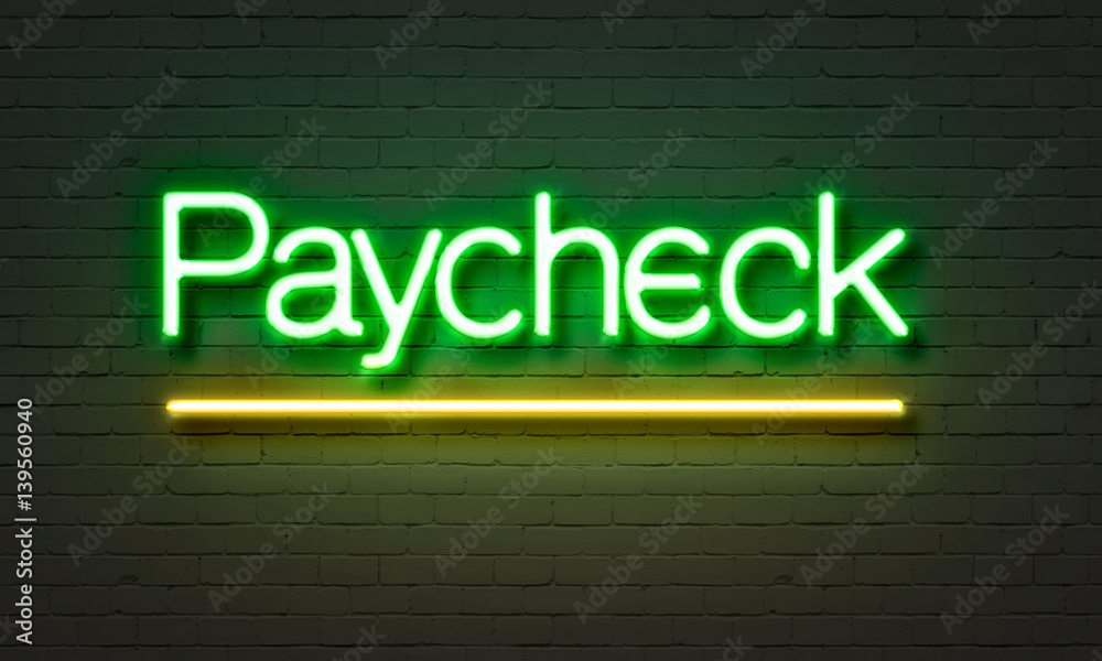 Paycheck neon sign on brick wall background.