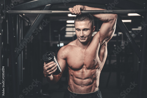 Muscular Man Resting After Exercise And Drinking From Shaker