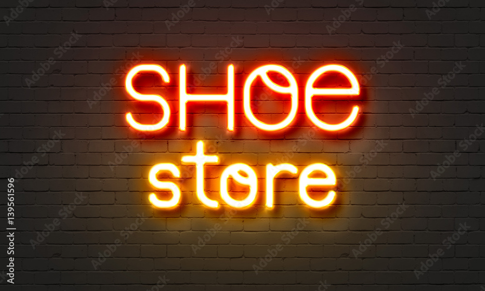 Obraz premium Shoe store neon sign on brick wall background.
