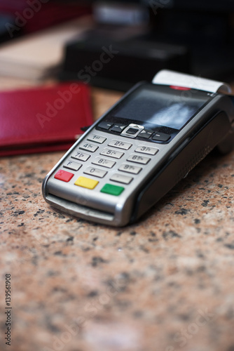 Close up of Credit Card Reader and Cash Register on background of Retail Shelves