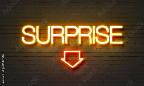 Surprise neon sign on brick wall background.